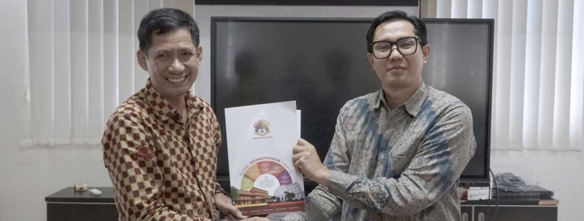 Dekan FIKOM Jamal bersama Direktur PT. Minergo Visi Maxima (Minergo Systems) Harry Hadi Syahputra menunjukkan dokumen Nota Kesepahaman. Foto: Media Kreatif