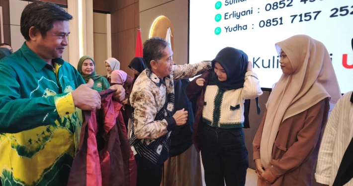 Direktur Eksekutif Yayasan Airlangga Dr. Agung Sakti Pribadi bersama Rektor Prof. Dr. Muhammad Ahsin Rifa'i secara simbolis menerima Mahasiswa Baru 2025 dengan memakaikan jas almamater merah marun kepada perwakilan mahasiswa baru. Foto: Vio/Media Kreatif