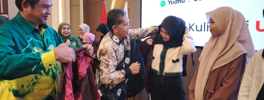 Direktur Eksekutif Yayasan Airlangga Dr. Agung Sakti Pribadi bersama Rektor Prof. Dr. Muhammad Ahsin Rifa'i secara simbolis menerima Mahasiswa Baru 2025 dengan memakaikan jas almamater merah marun kepada perwakilan mahasiswa baru. Foto: Vio/Media Kreatif