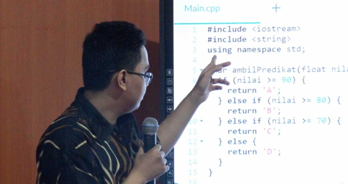 Yehezkiel Dio Sinolungan sedang menjelaskan makna baris-baris code C++. Foto: UKM DSC